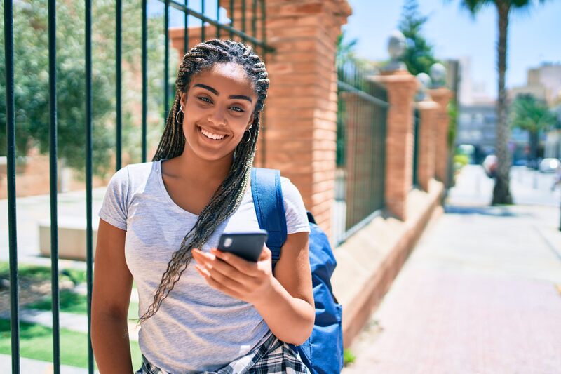 Young woman outdoors Young woman carrying a backpack and phone outdoors